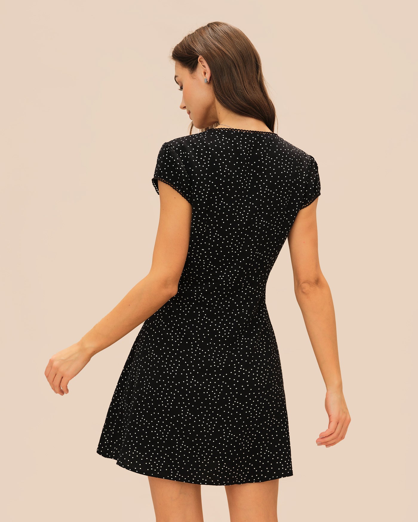 Schwarzes Mini-Kleid mit V-Ausschnitt und Tupfen