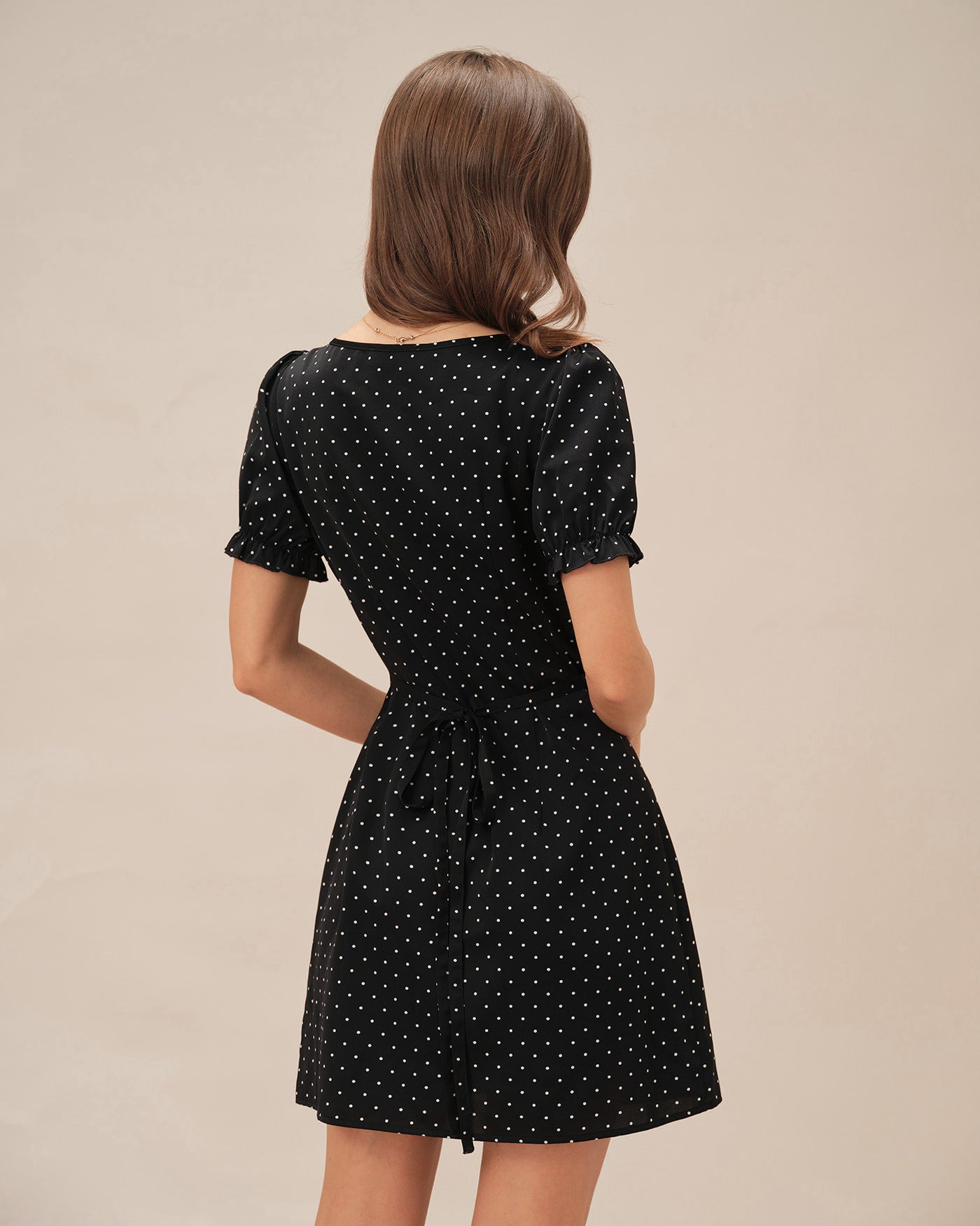 Schwarzes gepunktetes Mini-Kleid mit V-Ausschnitt