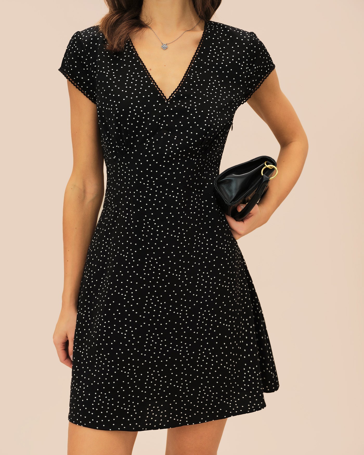 Schwarzes Mini-Kleid mit V-Ausschnitt und Tupfen